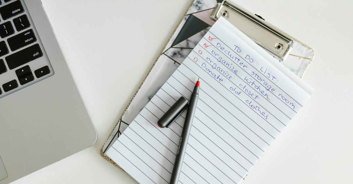 A neatly organized to-do list on a clipboard next to a laptop and pen, conveying productivity.